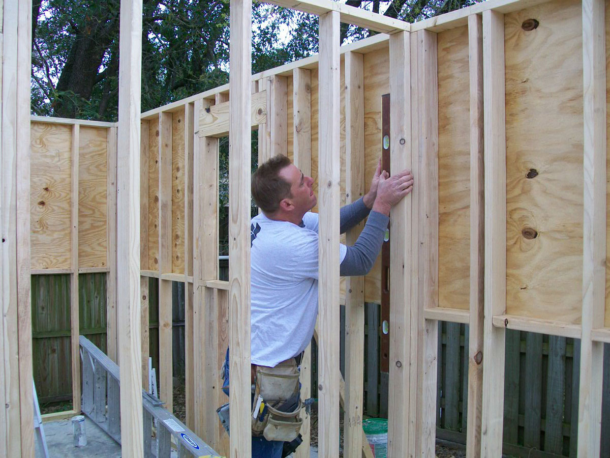 Here is one of our garage construction experts checking the alignment along one of on the walls.